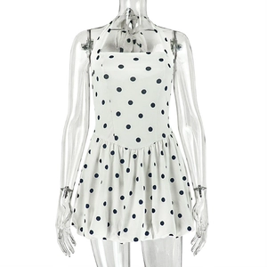 Detailed view of white polka dot halter dress with waist pleats and chiffon texture