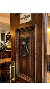 Détail d'un heurtoir de porte vintage en fonte à tête de cerf sur porte en bois