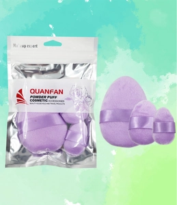 Detailed view of three purple velvet makeup puffs with transparent zipper bag