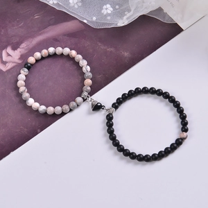 Close-up of pink zebra stone and black matte couple bracelets with heart magnet clasp