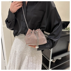 Detailed view of pink rhinestone drawstring bucket bag with chain strap and pearl charm