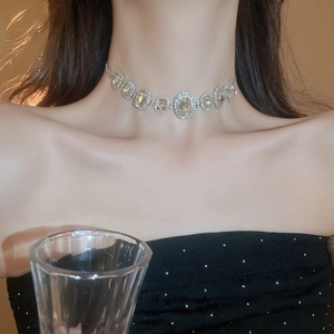 Detail of vintage silver choker necklace with oval yellow gems and sparkling crystals