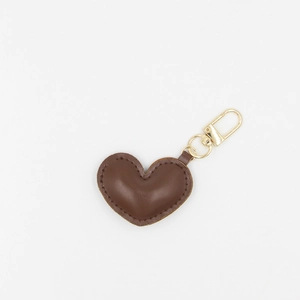 Close-up of brown PU leather heart keychain with decorative stitching and gold ring