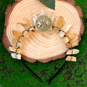 Handmade yellow crystal quartz crown with metal triple moon on natural moss background