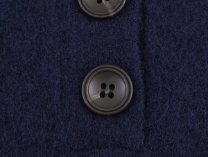 Close-up detail of dark blue knit fabric featuring two dark brown round four-hole buttons