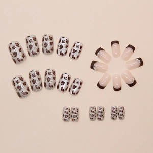 Dettaglio di unghie finte con stampa leopardata, glitter ed eleganti perle applicate