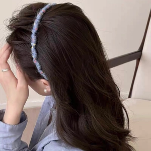 Dettaglio della fascia ondulata in maglia grigio-blu con pois colorati sul modello
