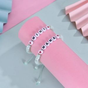 Close-up of Mama and Mini beaded bracelets with pink crystal beads and heart charms