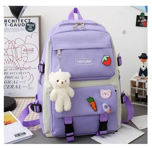 Detail of purple canvas backpack with cute strawberry patches and plush bear charm