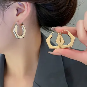 Minimalist geometric hexagonal hoop earrings in polished gold and silver metal finishes