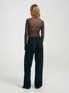 Vista posteriore dettagliata del top in rete leopardata con bordo ondulato e jeans