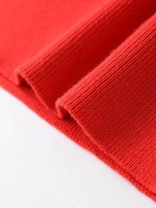Close-up of vibrant red ribbed knit fabric texture showing high-quality wool blend detail