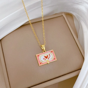 Close-up of golden necklace with pink and white enamel rectangular heart pendant