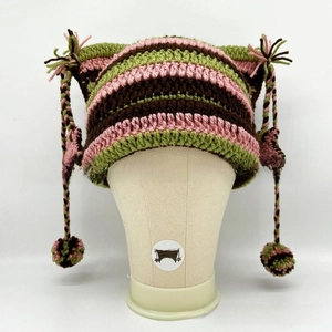 Detail of striped knit cat ear hat with colorful hanging pom-poms and braided tassels