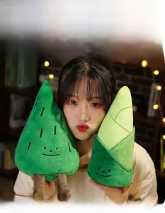 Close-up of soft pine tree and bamboo shoot plush pillows held in a warm cozy setting
