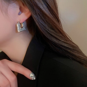 Orecchini geometrici quadrati in argento con strass scintillanti su modella