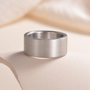 Macro view of 10mm matte brushed silver titanium steel band on a ceramic display