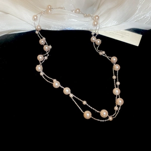 Detailed view of layered rose pearl necklace with multi-size pink-white pearls on silver chain
