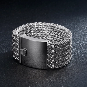 Close-up of wide stainless steel woven mesh bracelet with polished rectangular buckle