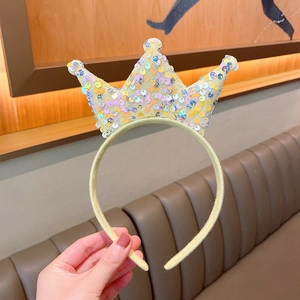 Close-up of sparkling rainbow sequins on a yellow princess crown headband for girls
