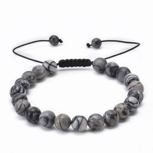 Detail of adjustable woven rope bracelet with grey and black natural stone beads