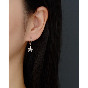 Macro side view of model wearing a sparkling S925 silver starfish drop earring with zircon