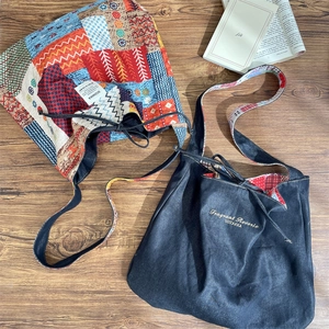 Detail of vintage tote bags showing ethnic patchwork and navy gold embroidery on wood
