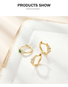 Macro detail of S925 sterling silver hoop earrings with white and green zircons