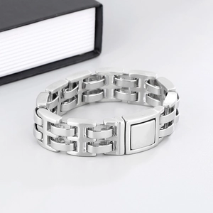 Macro detail of silver stainless steel H-link chain bracelet with square press buckle