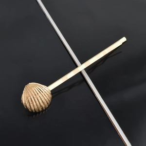 Close-up of golden shell hair clip with detailed textures and elegant metal finish