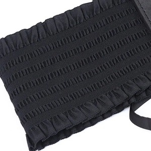 Close-up of black elastic lace corset belt featuring pleated fabric and ribbon detail