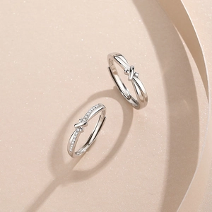 Adjustable S925 sterling silver couple rings with heart-shaped shadow on beige background