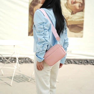 Pink lychee texture leather crossbody camera bag shown with a stylish wide woven strap