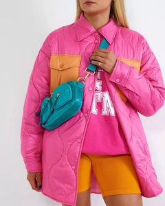 Dettaglio di un cappotto trapuntato rosa con borsa a tracolla blu per uno stile autunnale