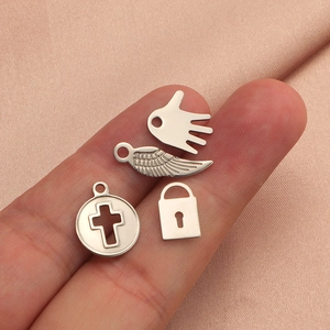 Lot de pendentifs en acier titane avec croix aile serrure et paume sur fond de soie rose