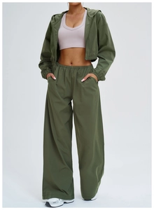Detail of olive green windproof sports set featuring cropped hooded jacket and wide-leg pants