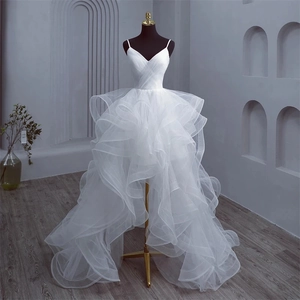 Detailed close-up of white high-low wedding dress with layered tulle and V-neck bodice