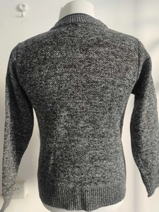 Detailansicht der dunkelgrauen Strickjacke mit grober Strickstruktur und Rippbündchen