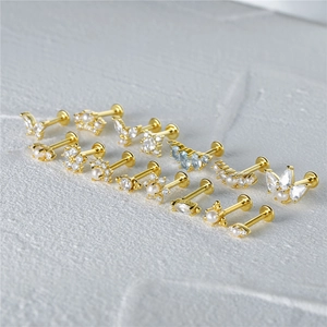 Close-up of golden S925 silver stud earrings with butterfly, pearl and zircon details
