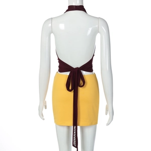 Détail d'un haut dos nu bordeaux avec nœud et mini-jupe jaune sur un mannequin de couture