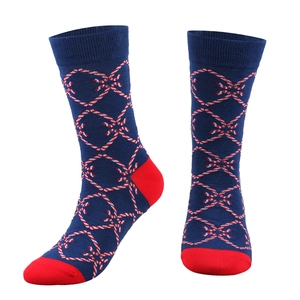 Detail of navy Christmas crew socks featuring candy cane patterns and red heel accents