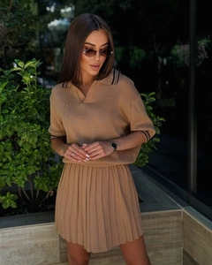 Détails d'un ensemble en tricot camel avec haut à col polo et jupe courte plissée