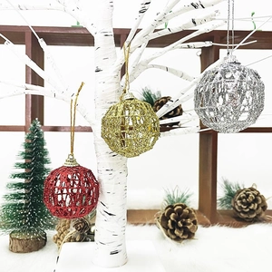 Hollow glitter Christmas ball ornaments in red gold and silver hanging on a white tree