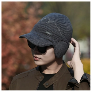 Detailed close-up of dark grey knitted earflap hat with brim and NY&JA logo label