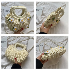 Detail view of handmade beige crochet shell bag with daisy decor and pearl strap