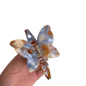 French butterfly hair claw with blue and orange marble texture acetate finish