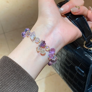 Detail view of purple amethyst beaded bracelet with gold accents on a wrist