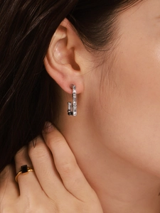 Close-up of model wearing silver bamboo-shaped rectangular earrings in 18K plated finish