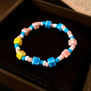 Detailansicht des Keramik-Armbands in Macaron-Farben in einer dunklen Geschenkbox