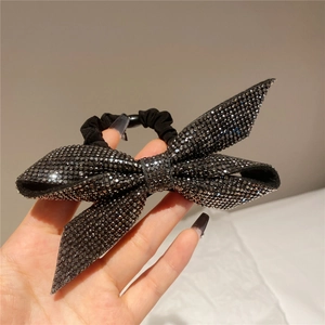 Close-up of sparkling rhinestone bow hair tie with high-quality elastic black rope